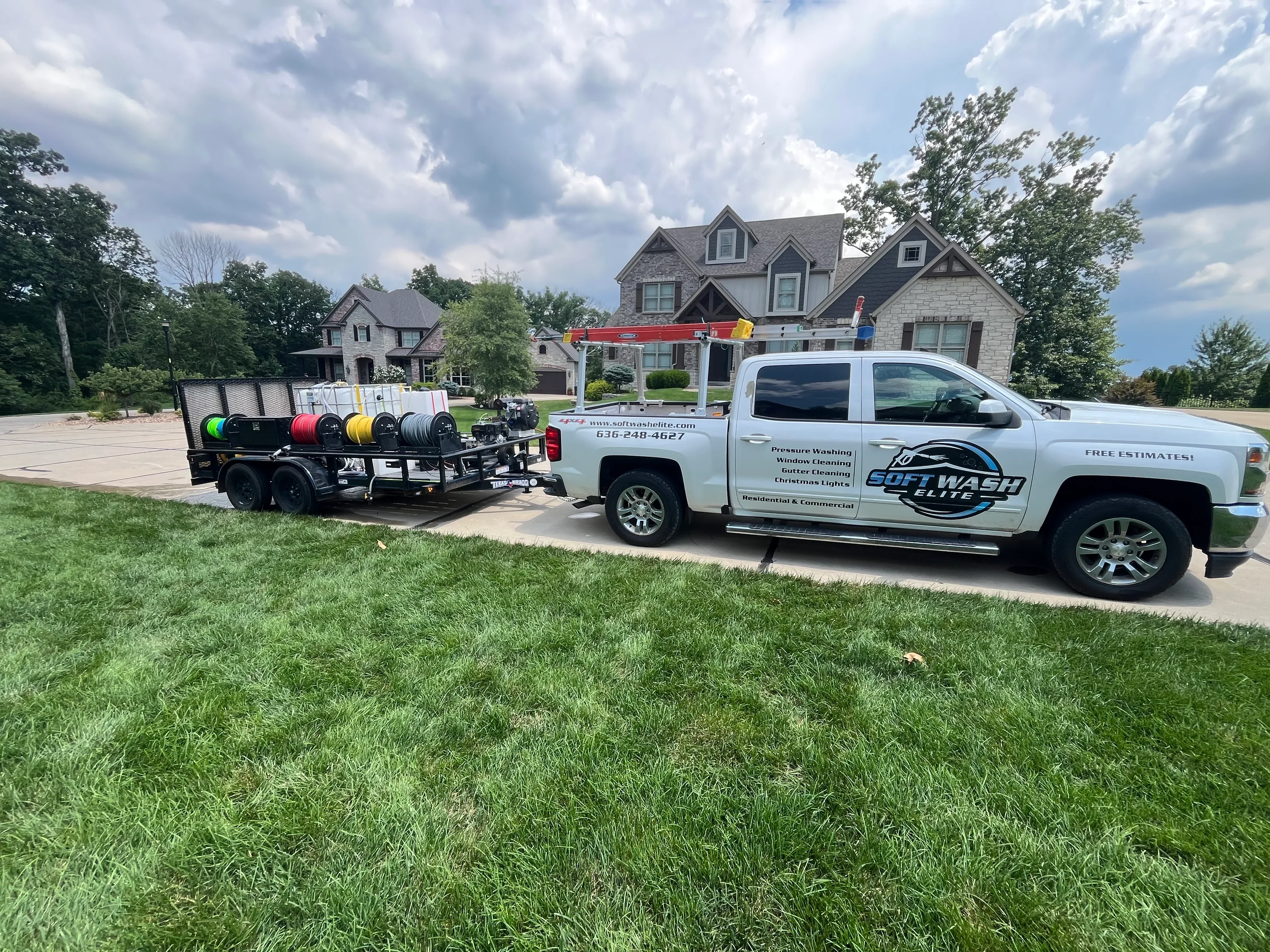 Pressure washing truck and equipment trailer at residential home in Wentzville