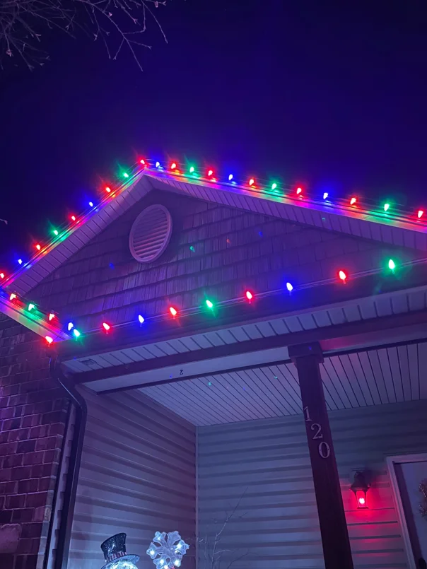 Multi-color LED holiday lights installed on residential garage roofline and soffit