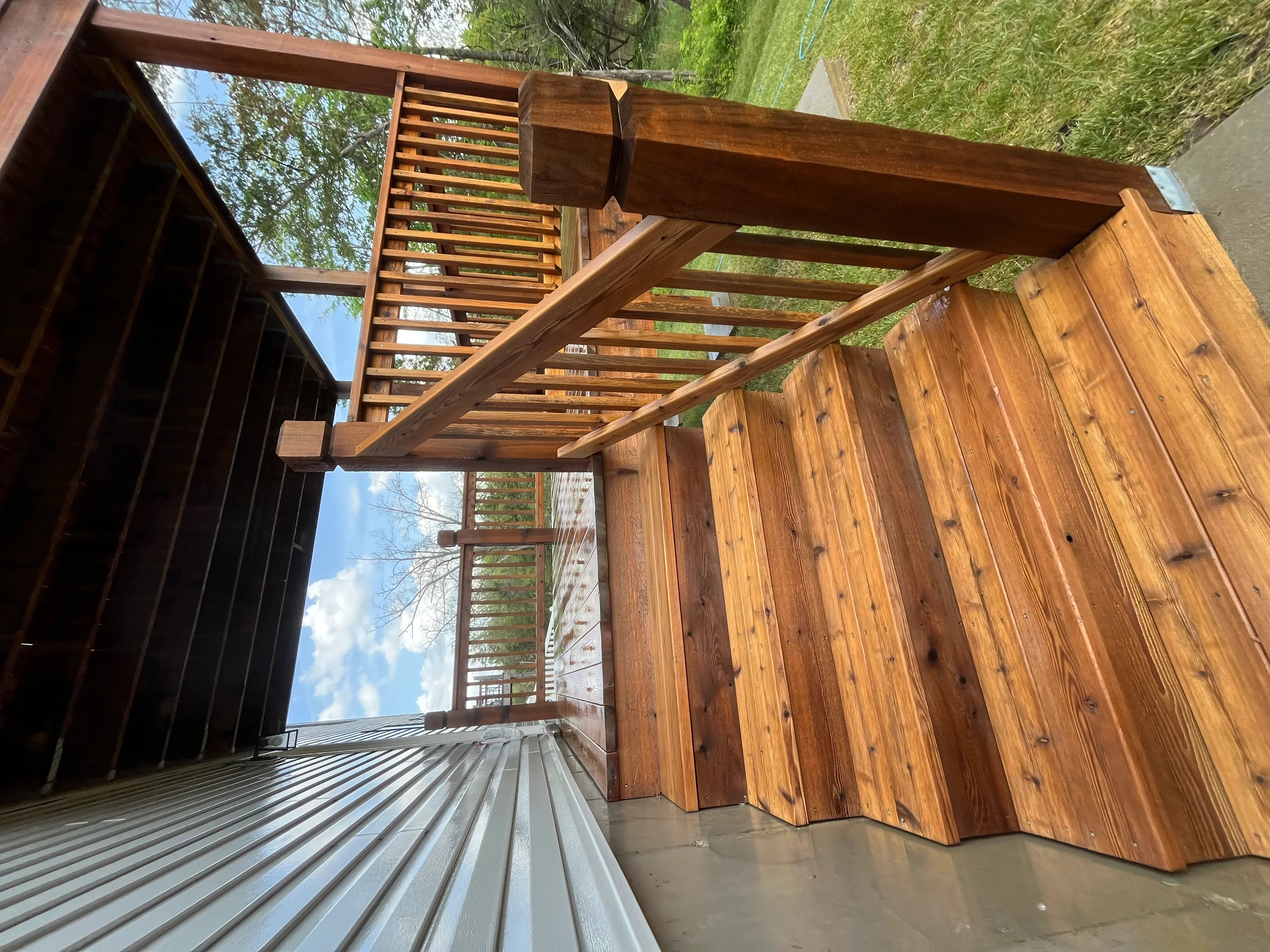 Cedar pergola with cleaned wood beams and composite deck after pressure washing service