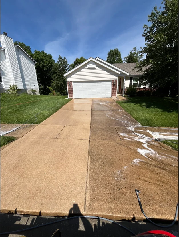 Concrete driveway before and after pressure washing, showing dirt removal and surface restoration