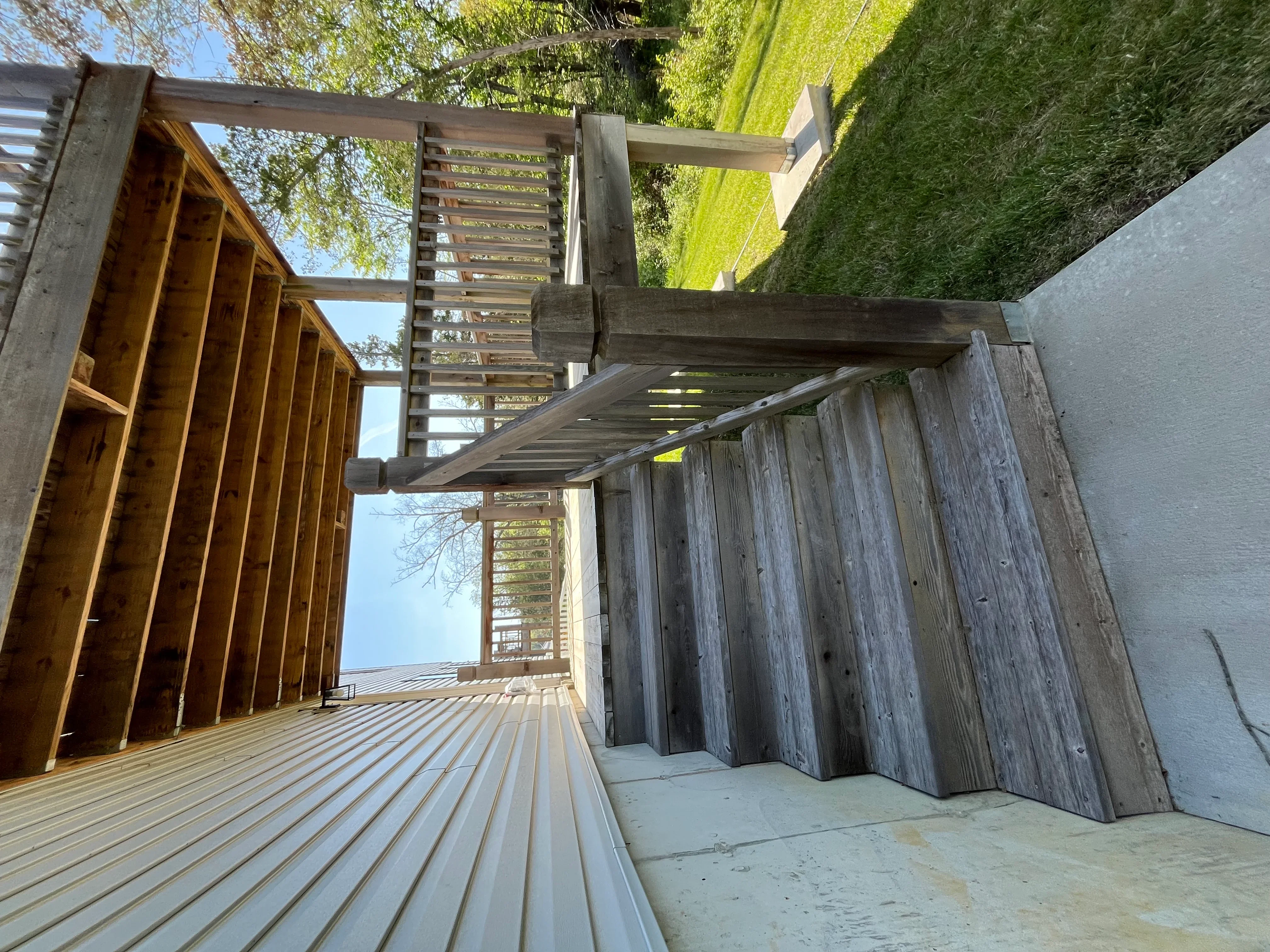 Clean composite deck with wooden pergola and pressure-washed fence panels