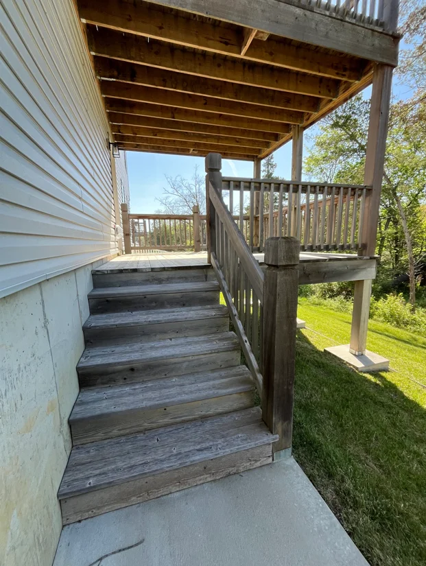 Pressure-washed wood deck stairs, railings, and covered patio with restored wood finish