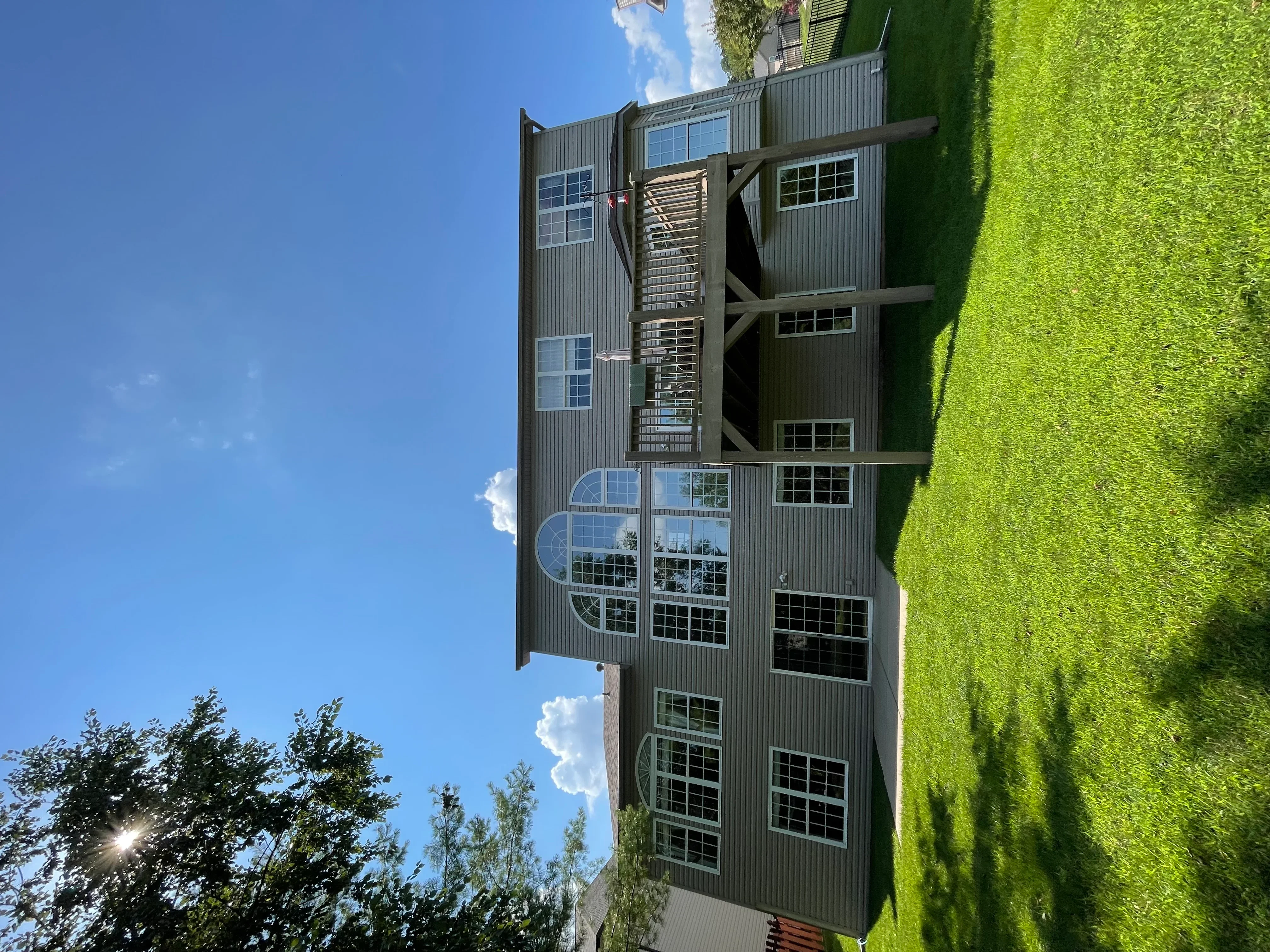 Multi-story commercial building with clean corrugated metal siding and windows after professional pressure washing