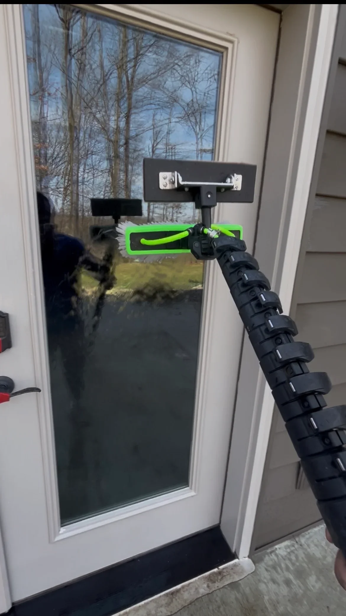 Window cleaning service using squeegee on residential glass door panel