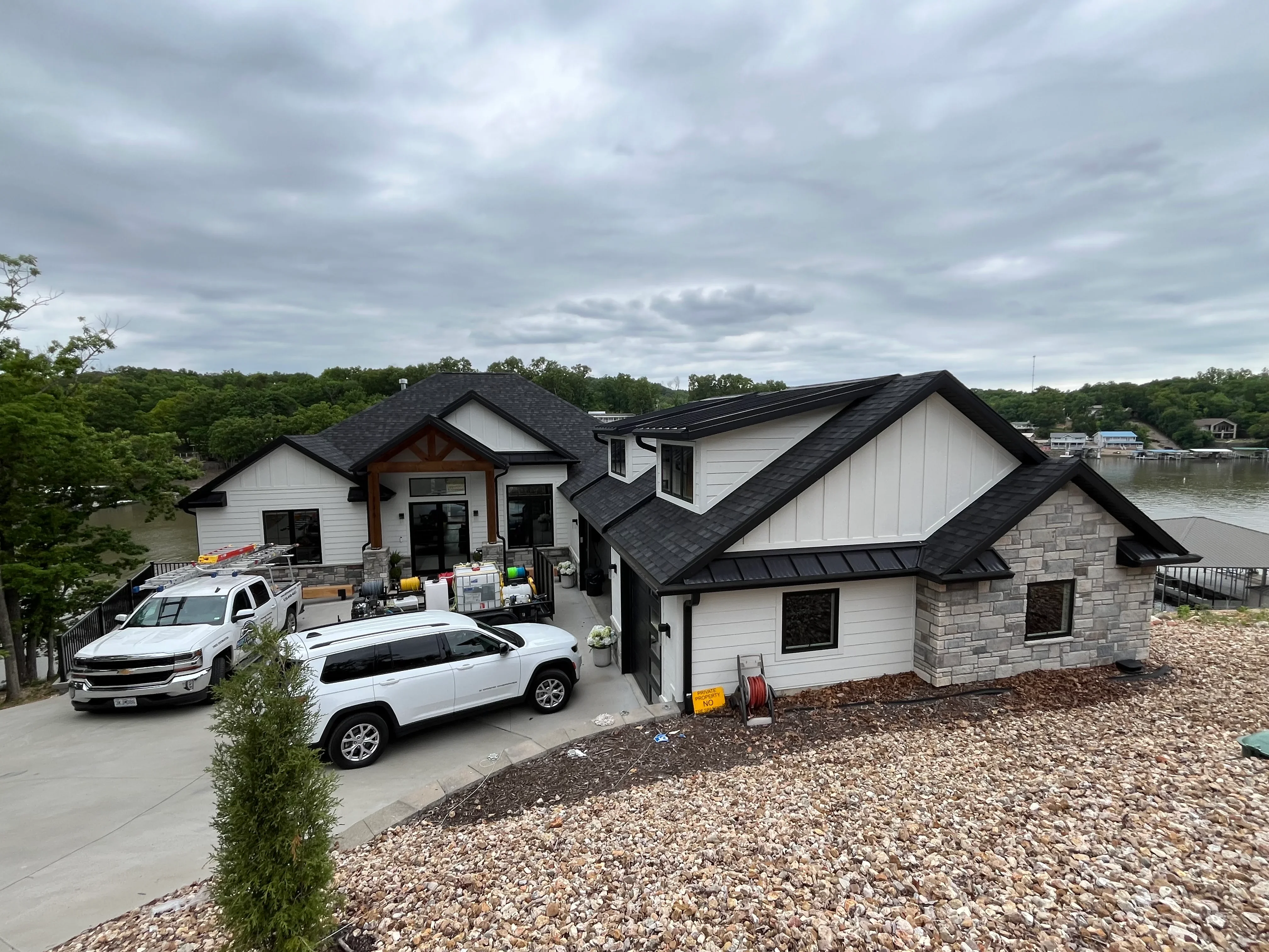 Modern waterfront home with white siding and dark roof after professional exterior cleaning