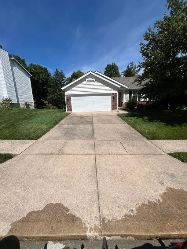 Concrete driveway before and after soft wash cleaning, showing dirt removal on residential home
