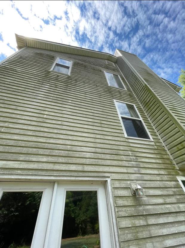 Clean horizontal vinyl siding on two-story home with white trim windows and gable roof