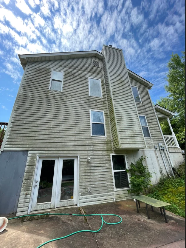 Two-story vinyl siding home after soft wash cleaning, bright white siding restored