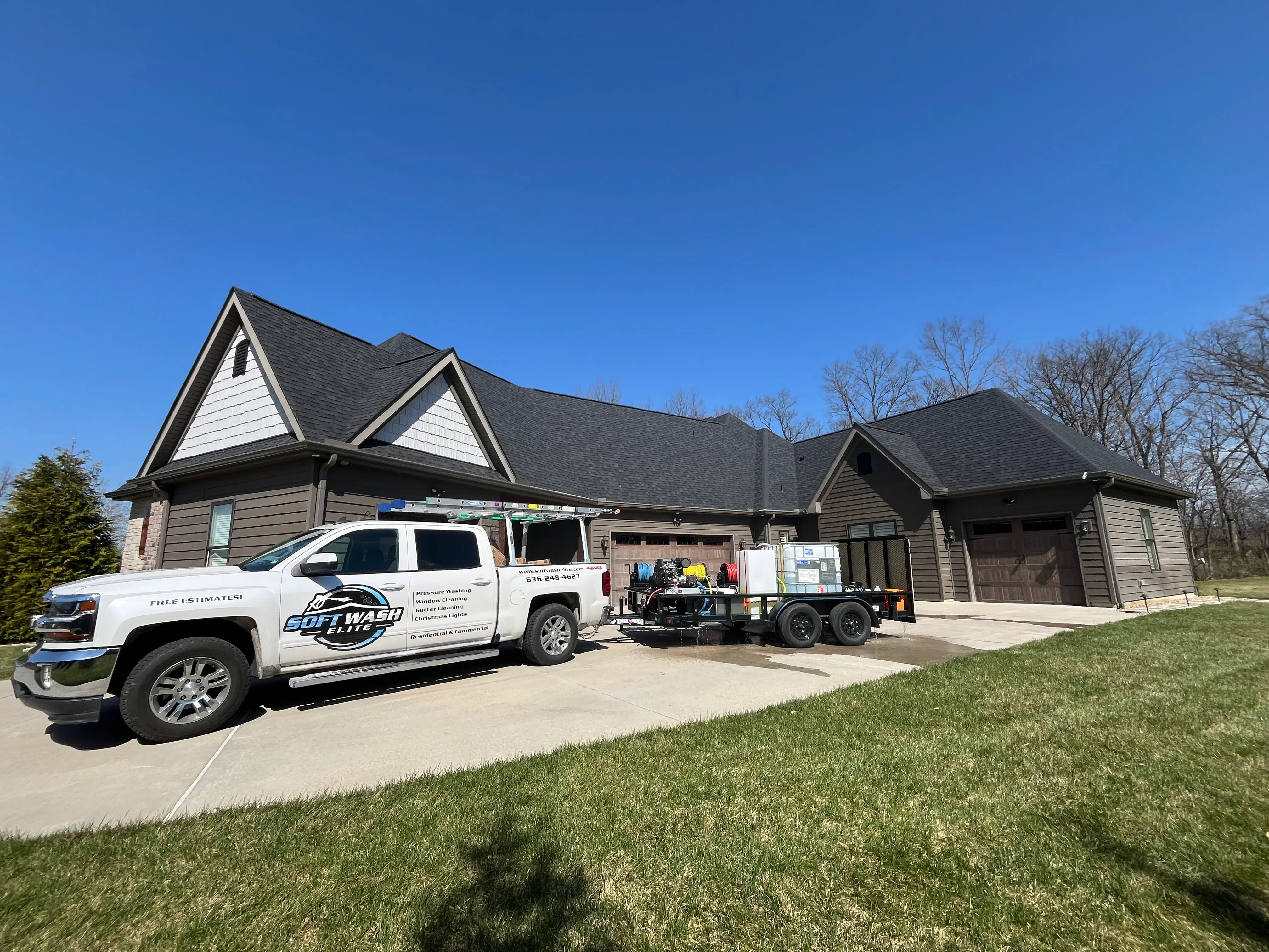 White service truck with soft wash equipment parked at residential home with dark roof