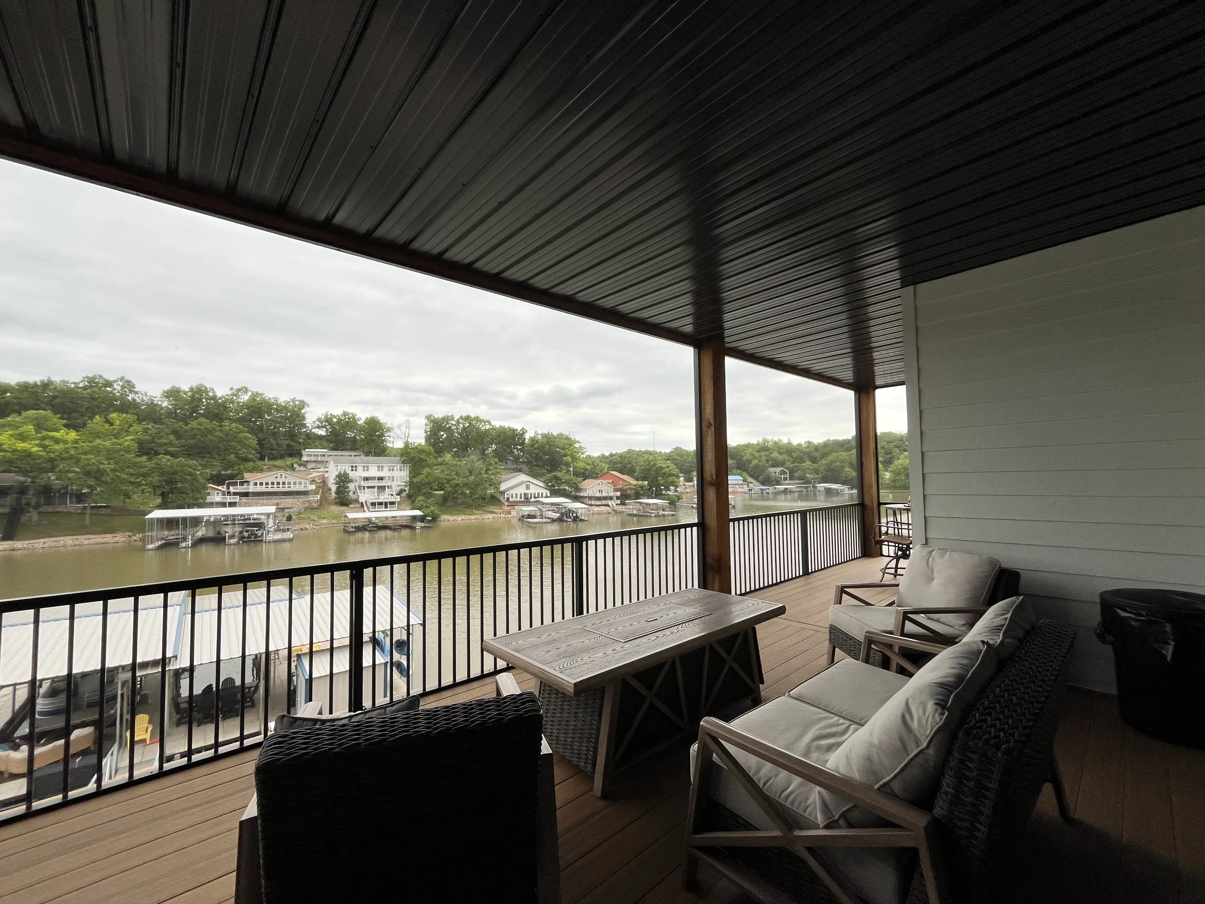 Clean composite deck with white railings overlooking river and wooded landscape