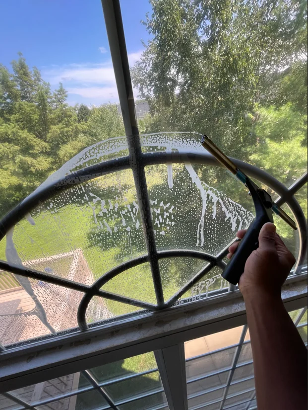 Clean residential window with metal frame and screen overlooking green landscape