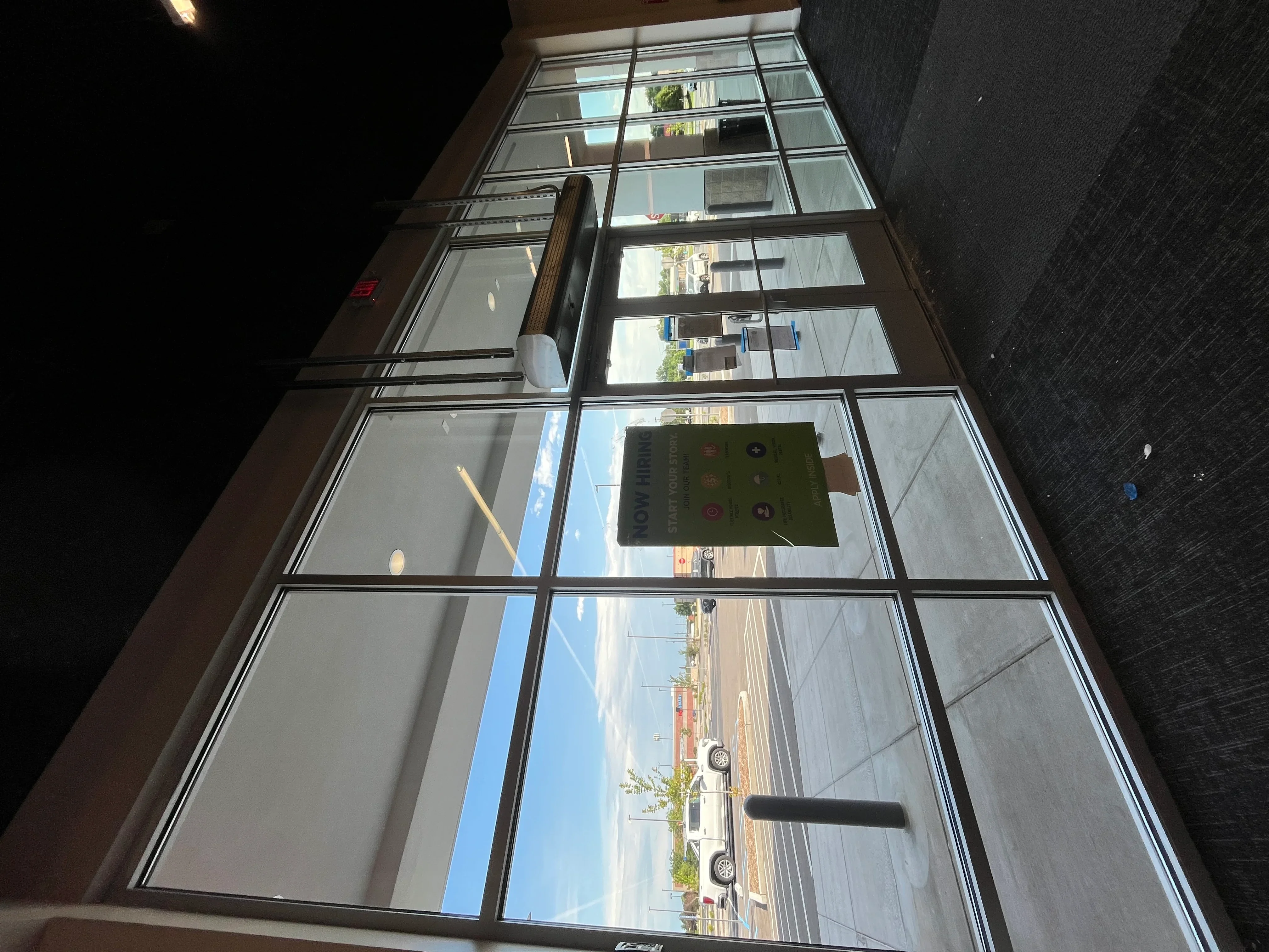 Clean commercial storefront windows with grid pattern reflecting street view