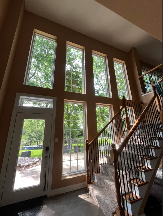 Clean multi-pane windows and glass door in residential entryway with wood frames